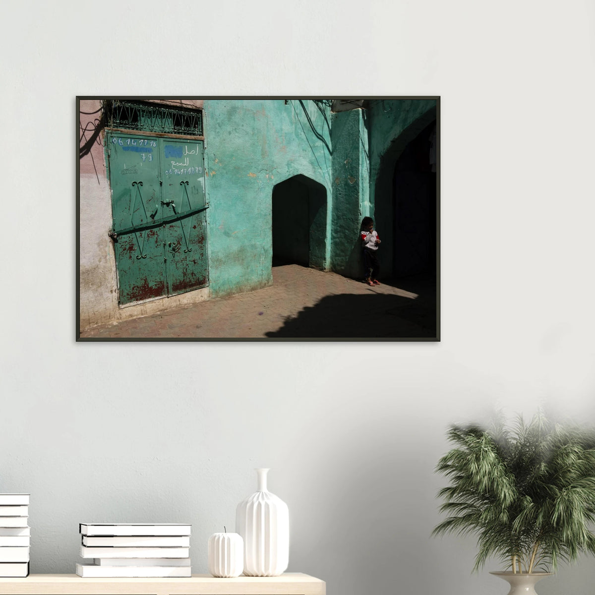 Candid fine art photograph titled 'Childhood in the Medina' featuring a young child standing in the shadows of a vibrant turquoise alley in Morocco - photography print by Paulo Côrte-Real