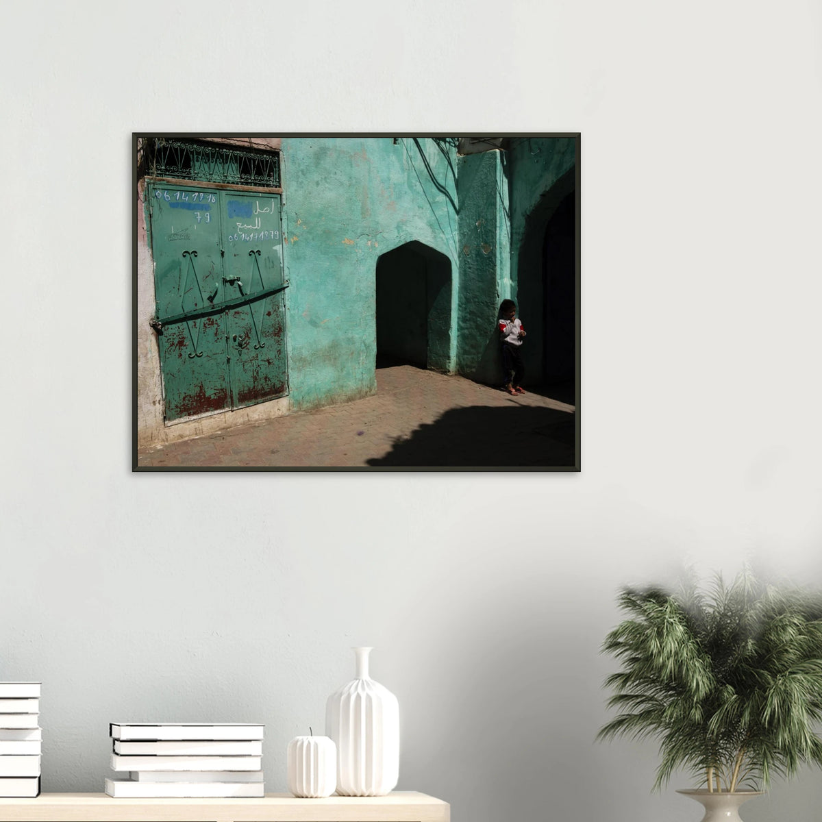 Candid fine art photograph titled 'Childhood in the Medina' featuring a young child standing in the shadows of a vibrant turquoise alley in Morocco - photography print by Paulo Côrte-Real