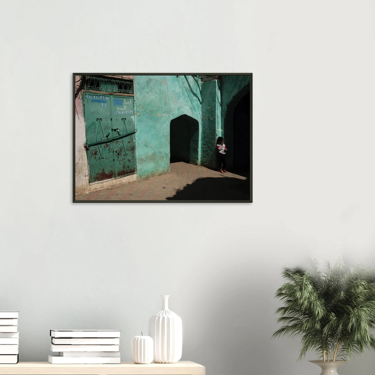 Candid fine art photograph titled 'Childhood in the Medina' featuring a young child standing in the shadows of a vibrant turquoise alley in Morocco - photography print by Paulo Côrte-Real