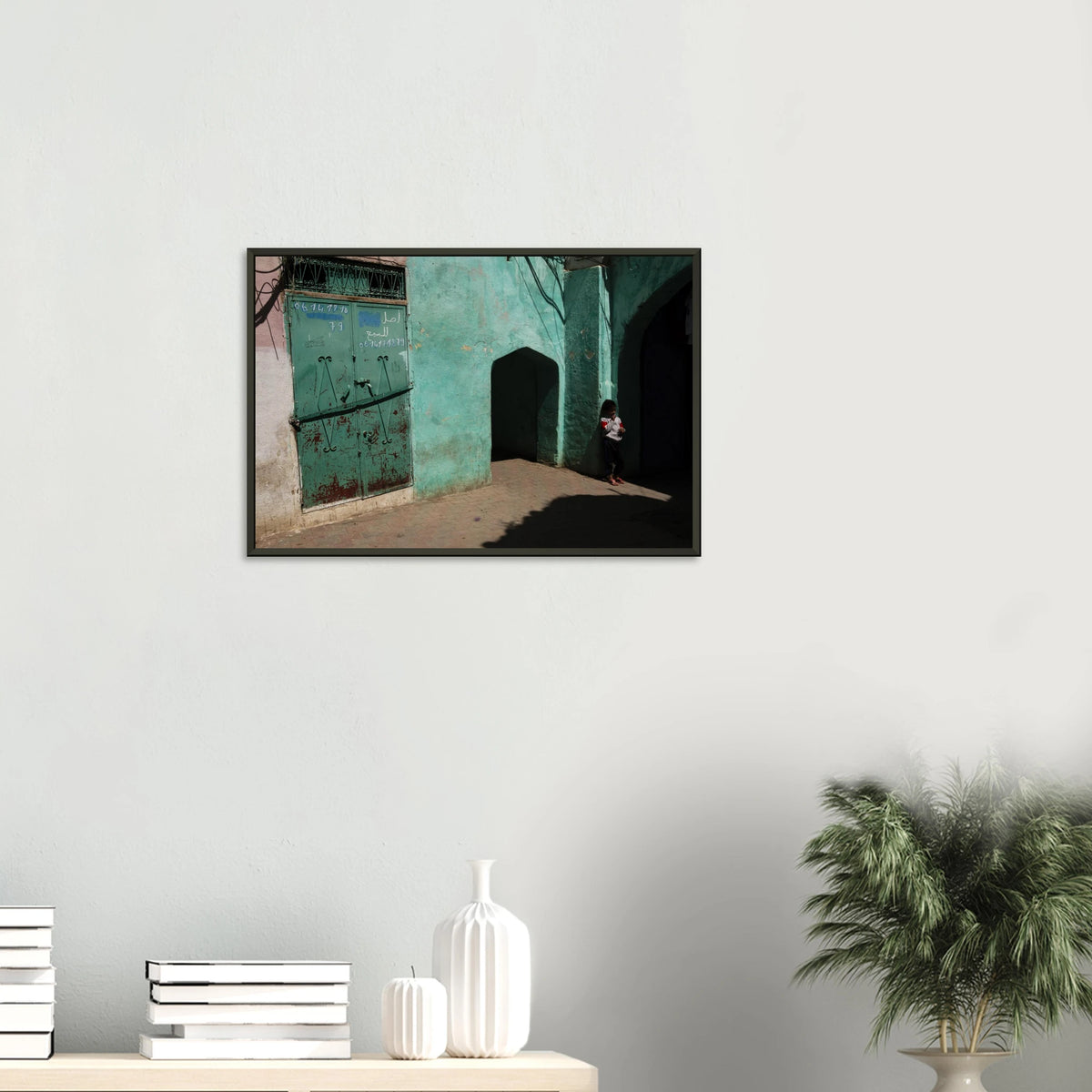 Candid fine art photograph titled 'Childhood in the Medina' featuring a young child standing in the shadows of a vibrant turquoise alley in Morocco - photography print by Paulo Côrte-Real